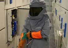 Engineer in arc flash protection suit performing electrical inspection