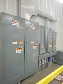 Industrial panelboard interior showing breakers and bus assembly evaluated for NEC 110.16 arc flash labeling